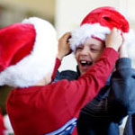 two boys wearing Santa hats