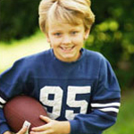 young boy running with a football