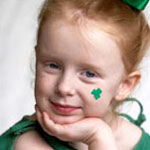 little red headed girl with green shamrock painted on her face
