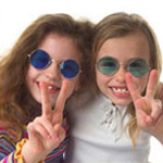 two girls wearing colored glasses and flashing peace signs