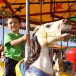 child riding carousel at amusement park