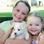 two girls holding a puppy