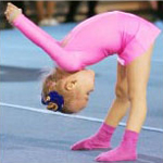 little girl in pink leotard doing gymnastics