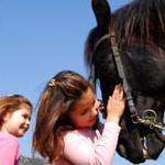 two girls petting a horse