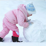 Little girl making a snow man