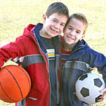 two boys holding sports balls