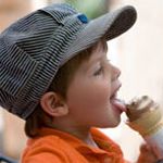 little boy wearing a train conductor cap