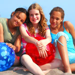 girls on beach with beach balls