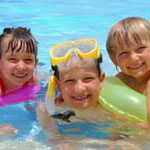 three children swimming in a pool